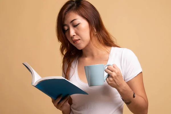 Giovane donna asiatica con un libro e una tazza di caffè . — Foto Stock