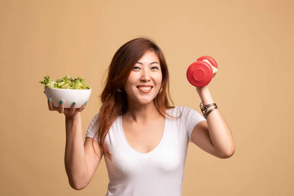 Здоровая азиатка с гантелями и салатом . — стоковое фото