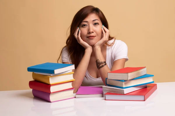 Ung asiatisk kvinna läsa en bok med böcker på bord. — Stockfoto