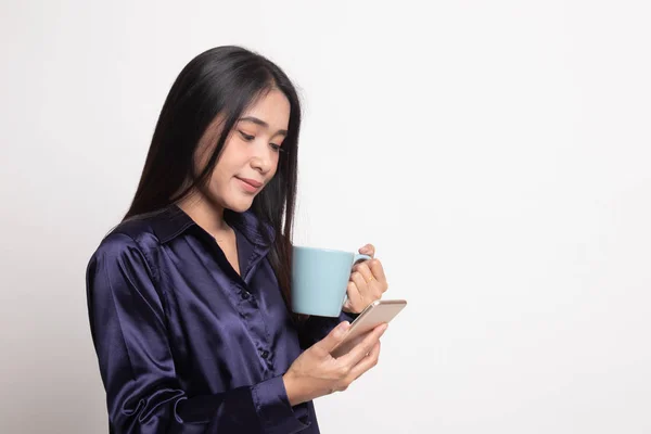 Jonge Aziatische vrouw met mobiele telefoon en koffiekopje. — Stockfoto