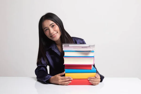 Heureuse jeune femme asiatique lire un livre avec des livres sur la table . — Photo