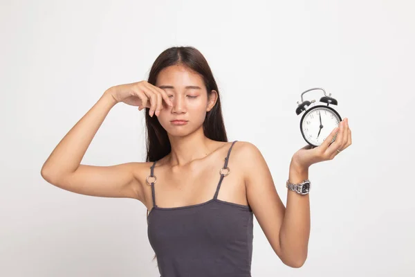 Sleepy joven asiática mujer con un reloj en la mañana . — Foto de Stock