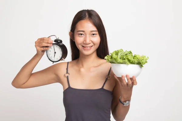 Ung asiatisk kvinna med klocka och sallad. — Stockfoto