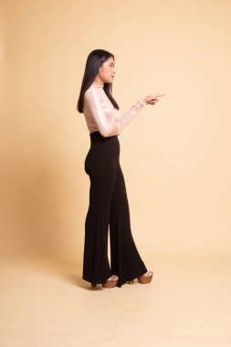 Güzel genç Asyalı kadın işaret tam vücut yan görünüm.