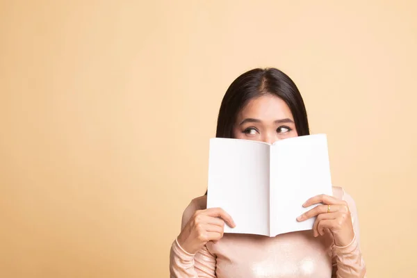 Joven asiática mujer con un libro cubrir su cara . — Foto de Stock