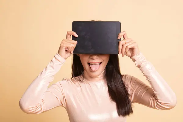 Young Asian woman with a computer tablet over her face. — Stock Photo, Image