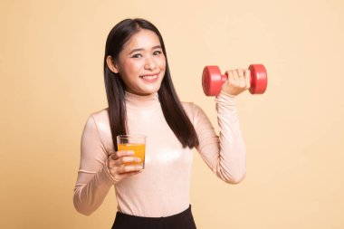 Genç Asyalı kadın dumbbell içki portakal suyu ile.