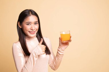 Genç Asyalı kadın başparmak yukarıya içki portakal suyu.