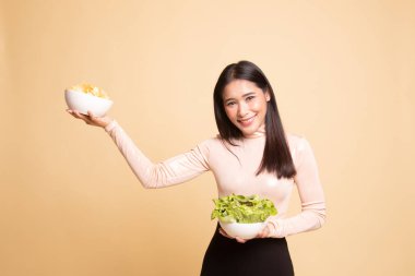 Patates kızartması ve salata ile genç Asyalı kadın.