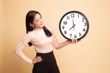 Saati olan genç Asyalı kadın..