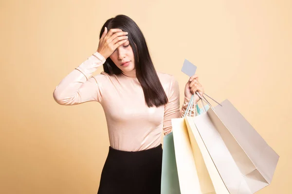 Mulher asiática jovem infeliz com sacos de compras e cartão de crédito . — Fotografia de Stock