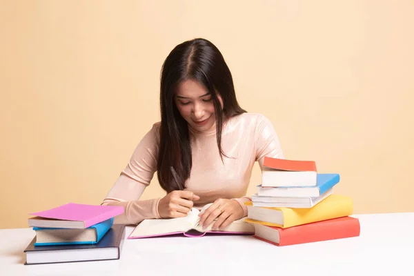 Jovem mulher asiática ler um livro com livros na mesa . — Fotografia de Stock