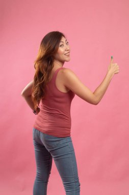 Genç Asyalı kadın sıra arka başparmak yukarıya.