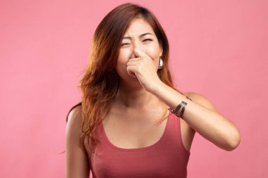 Kötü bir koku yüzünden burnunu tutan genç Asyalı kadın.