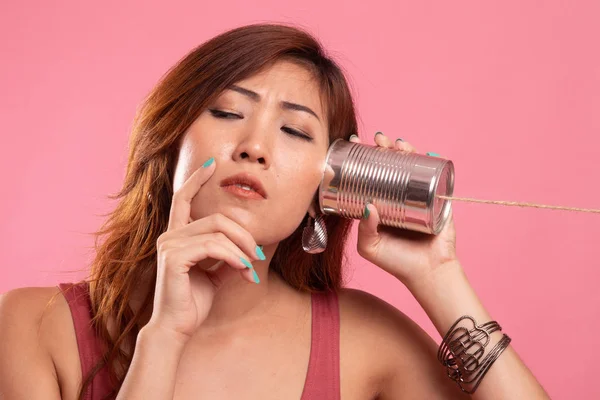 Jeune asiatique femme audition avec étain peut téléphone et penser . — Photo