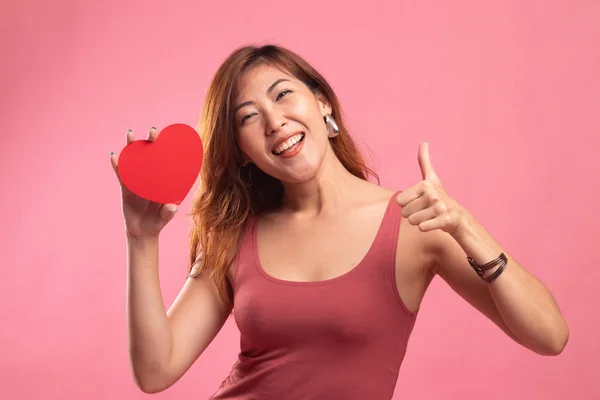 Asian woman thumbs up with red heart.