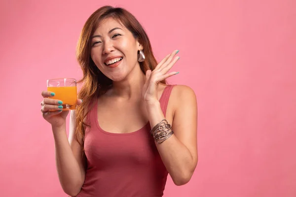 Jovem mulher asiática feliz beber suco de laranja . — Fotografia de Stock