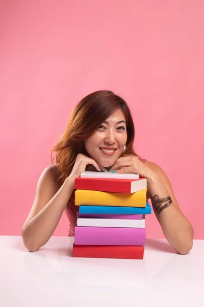 Felice giovane donna asiatica leggere un libro con libri sul tavolo . — Foto Stock