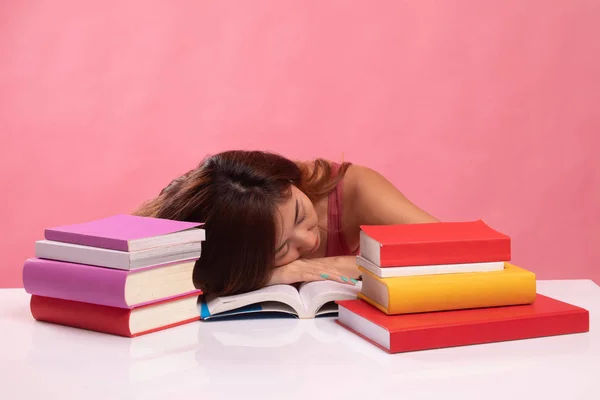 Esausto giovane donna asiatica dormire con libri sul tavolo . — Foto Stock