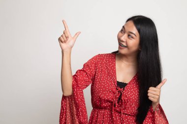Genç Asyalı kadın noktası ve başparmak yukarıya.