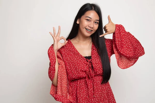 Junge asiatische Frau zeigen mit Telefon Geste und ok Zeichen. — Stockfoto