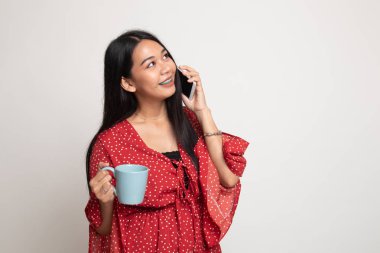 Genç Asyalı kadın ile cep telefonu ve kahve fincanı.