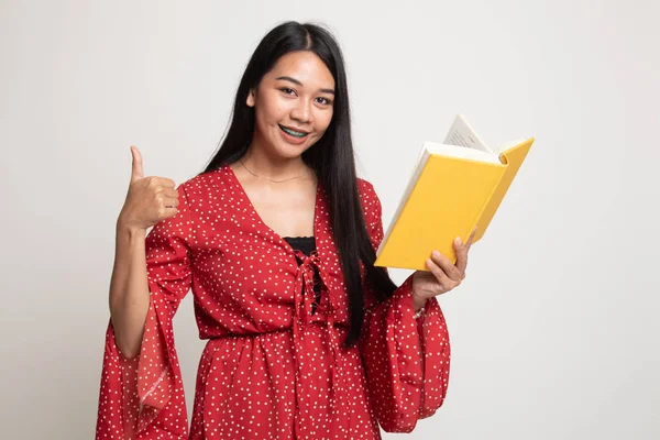 Mladá asijská žena palec nahoru s knihou. — Stock fotografie