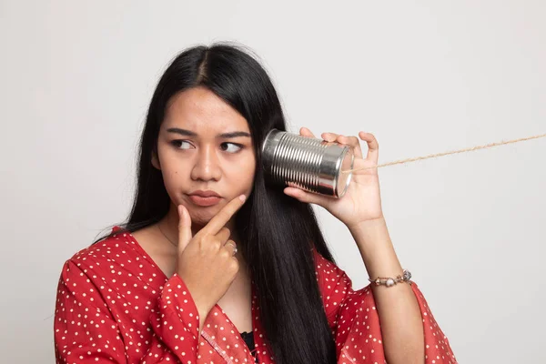 Jovem mulher asiática ouvir com lata pode telefone e pensar . — Fotografia de Stock