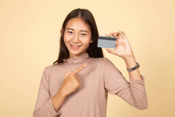 Jovem mulher asiática apontar para um cartão em branco . — Fotografia de Stock