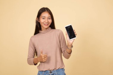 Genç Asyalı kadın ortaya başparmak ile cep telefonu.