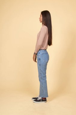 Güzel genç Asyalı kadın tam vücut yan görünüm.