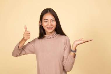 Güzel genç Asyalı kadın göstermek palm el ve başparmak yukarıya.