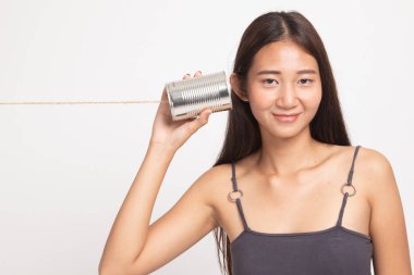 Teneke kutu telefon ile genç Asyalı kadın.