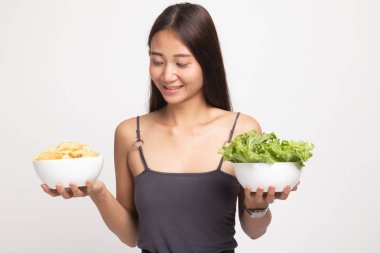 Patates kızartması ve salata ile genç Asyalı kadın.