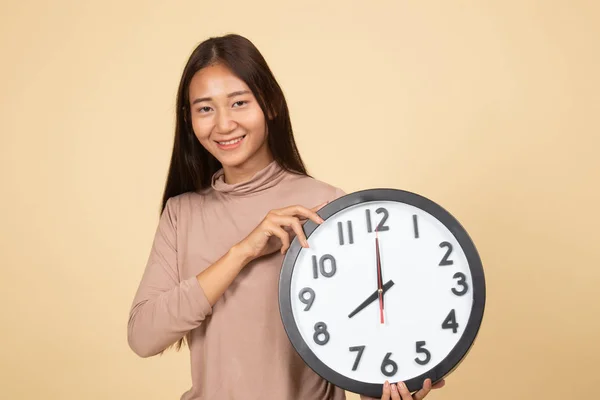 Jeune femme asiatique avec une horloge. — Photo