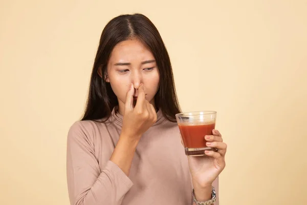 Young Asian woman hate tomato juice.