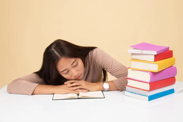 Уставшая молодая азиатка спит с книгами на столе . — стоковое фото