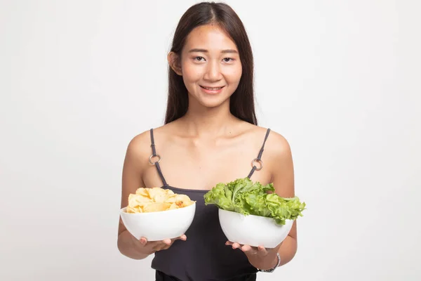 Ung asiatisk kvinna med potatischips och sallad. — Stockfoto