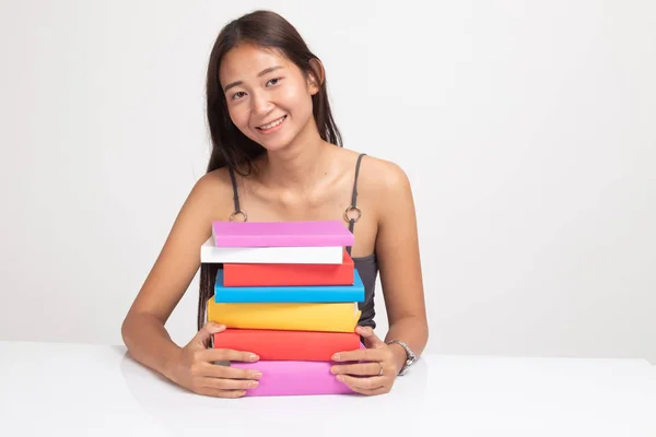 Felice giovane donna asiatica leggere un libro con libri sul tavolo . — Foto Stock