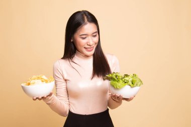 Patates kızartması ve salata ile genç Asyalı kadın.