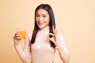 Genç Asyalı kadın içki portakal suyu göster Ok işareti.