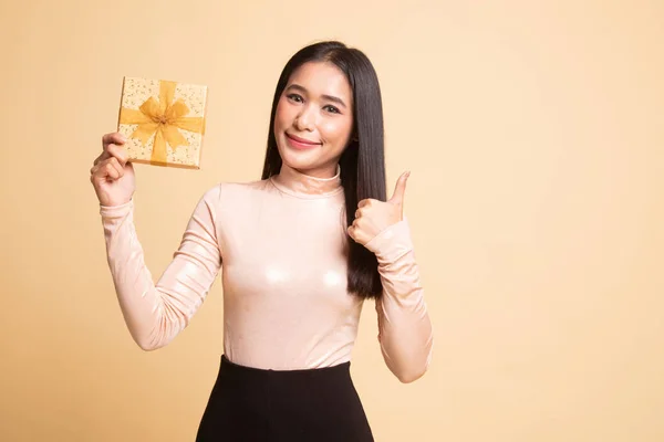 Giovane donna asiatica pollice in su con una scatola regalo . — Foto Stock