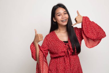 Genç Asyalı kadın başparmak telefon jest ile göstermek yukarıya.