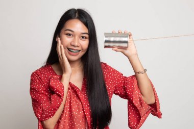 Mutlu genç Asyalı kadın Dinle konserve telefon ile.