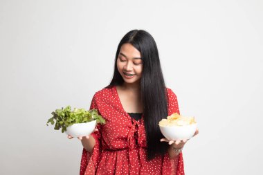 Patates kızartması ve salata ile genç Asyalı kadın.