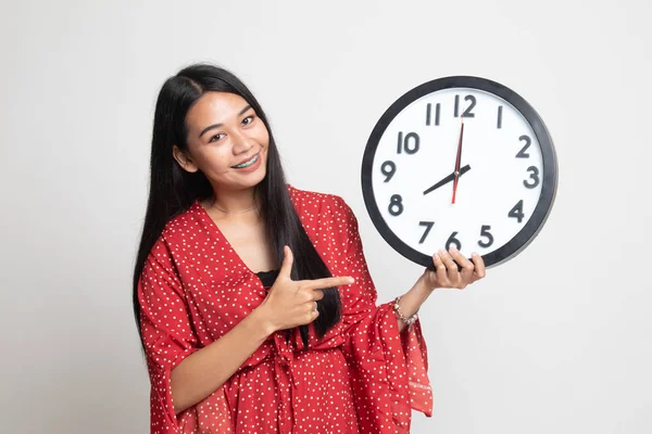 Jovem mulher asiática apontar para um relógio . — Fotografia de Stock