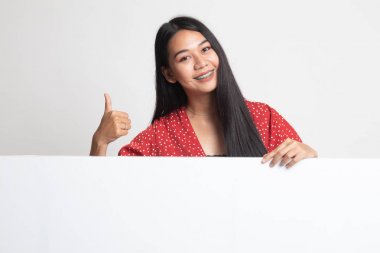 Genç Asyalı kadın ortaya başparmak boş işaretiyle.