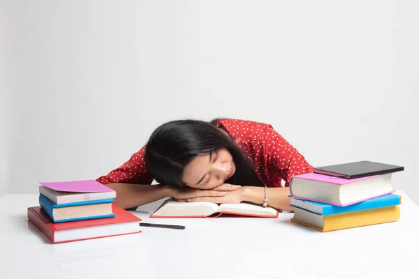 Jovem asiática exausta dorme com livros na mesa . — Fotografia de Stock