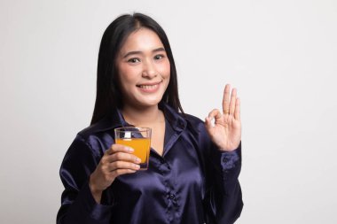 Genç Asyalı kadın içki portakal suyu göster Ok işareti.
