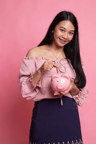 Sikke ve domuz para banka ile Asyalı kadın. — Stok fotoğraf